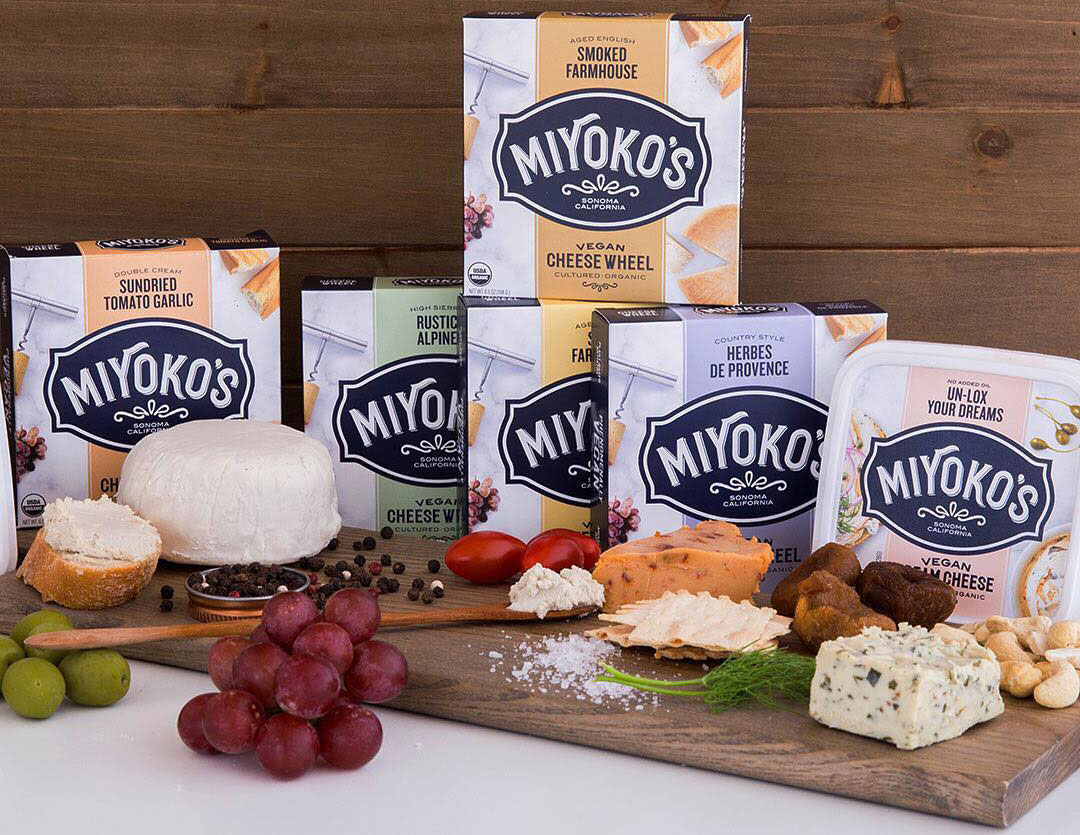 cutting board with crackers and various Miyoko cheeses