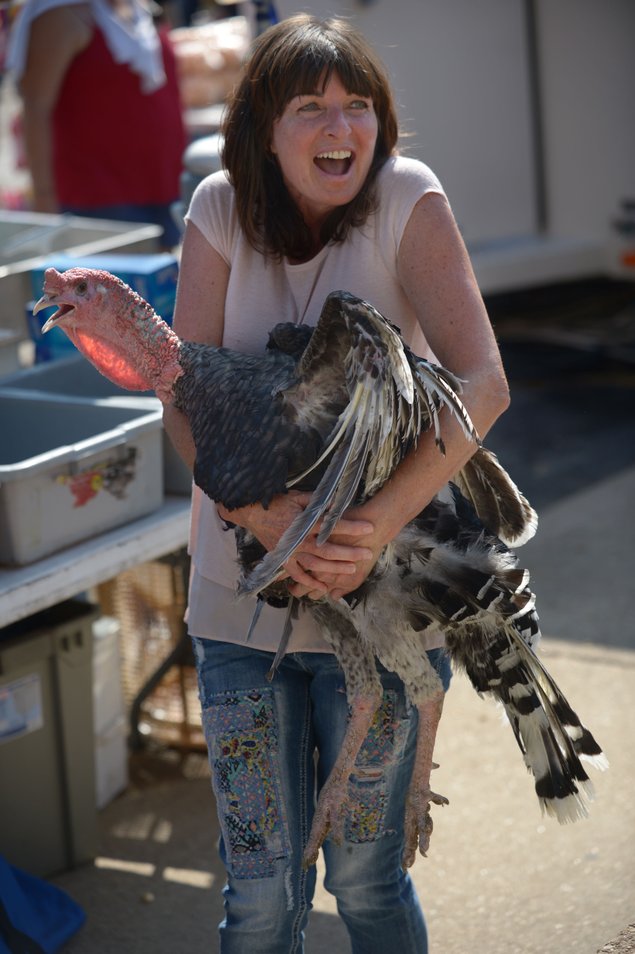 Woman laughing as she clutches a turkey