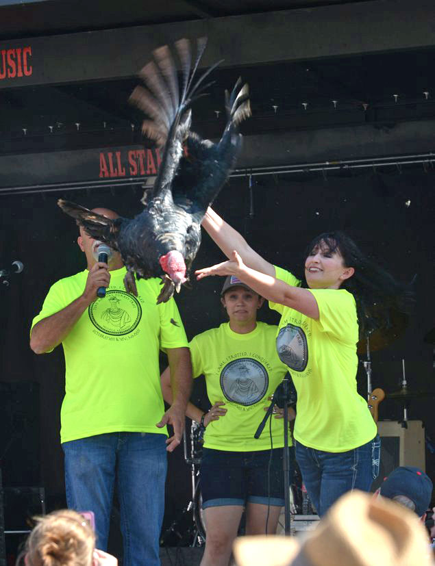 Woman throwing a turkey off a stage and into a crowd